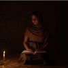 Figura seduta con una candela accesa davanti mentre riflette, simbolo della delicatezza emotiva legata ai legamenti d’amore