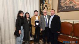 Il sindaco di Udine De Toni e la famiglia Ligi consegnano una targa a Endrit Dedaj a Palazzo D'Aronco