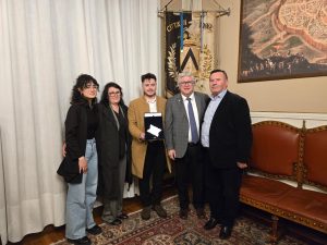 Il sindaco di Udine De Toni e la famiglia Ligi consegnano una targa a Endrit Dedaj a Palazzo D'Aronco