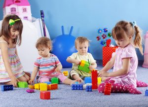 Bambini che giocano in un asilo nido, simbolo del benessere sociale in Friuli Venezia Giulia