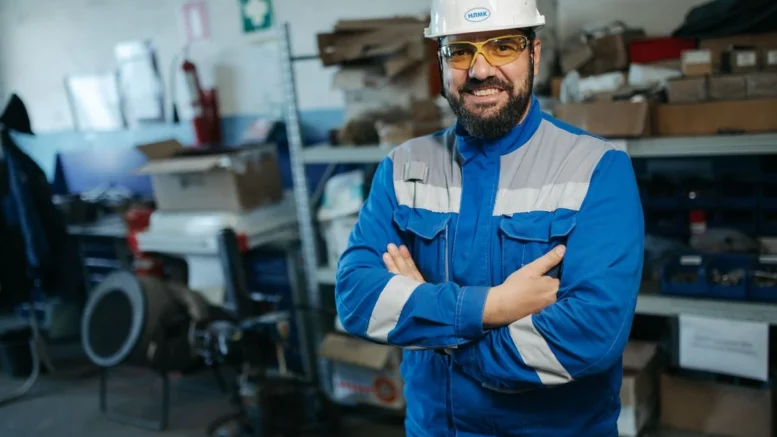 Lavoratore con casco e dispositivi di protezione in azienda